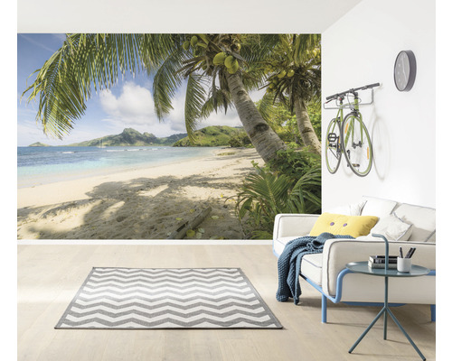Wohnzimmer mit Fototapete einer tropischen Strandlandschaft, Sofa und Teppich
