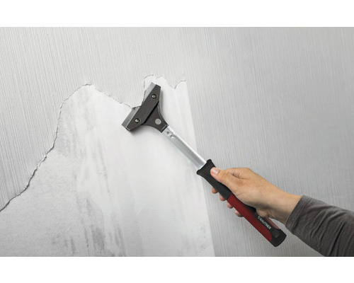 Tapetenschaber im Einsatz zum Entfernen von Tapeten von einer Wand