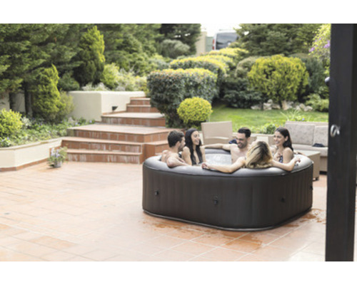 Jacuzzi gonflable dans le jardin avec des personnes qui se détendent.