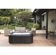Jacuzzi gonflable sur une terrasse avec mobilier de jardin et plantes