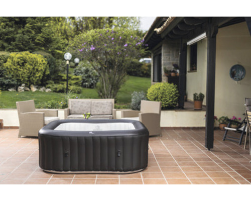 Jacuzzi gonflable sur une terrasse avec mobilier de jardin et plantes
