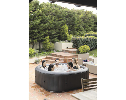 Jacuzzi gonflable avec six personnes dans le jardin