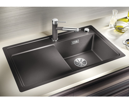 Évier avec égouttoir et robinet dans un environnement de cuisine clair.