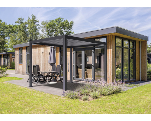 Holzhaus mit Terrasse, Pergola, Gartentisch und Stühlen auf Rasen