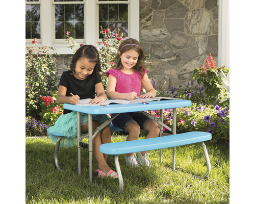Kindersitzgruppe mit Tisch und Bänken im Garten, zwei Mädchen malen auf dem Tisch