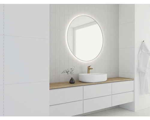 Salle de bain lumineuse avec miroir rond, lavabo et meuble-lavabo