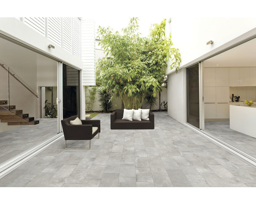 Terrasse lumineuse avec dalles de sol grises, mobilier de siège et plantations