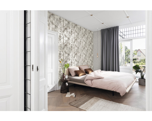 Chambre lumineuse avec lit, papier peint à motifs, rideaux et plancher en bois