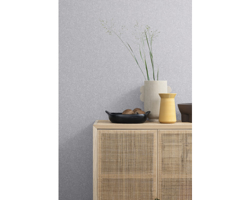 Papier peint à motifs au-dessus d''une armoire à façade en rotin, avec vases et un bol dessus