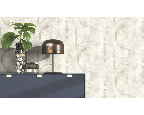 Papier peint décoratif avec motif de cercles abstraits dans une pièce lumineuse avec commode, lampe et plantes.