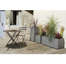 Gartenszene mit Tisch, Stuhl und bepflanzten Pflanzkästen auf einer Terrasse