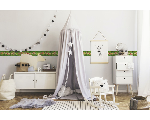 Chambre d''enfant avec bordure à motif animalier, lit à baldaquin et meubles blancs