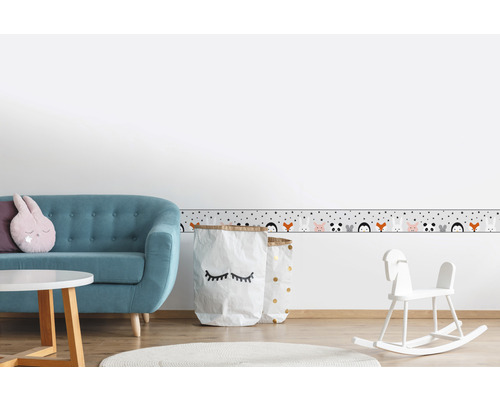 Chambre d''enfant avec canapé, table, jouets et bordure à motifs d''animaux