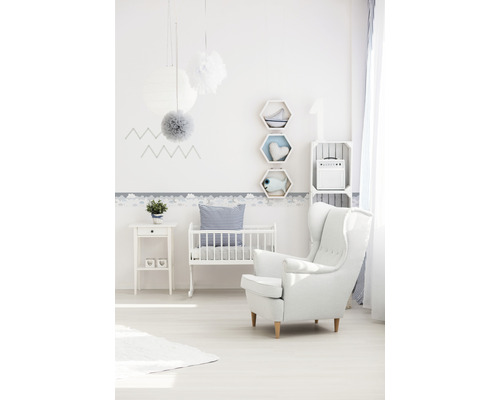 Chambre d''enfant avec lit de bébé, fauteuil et décorations murales