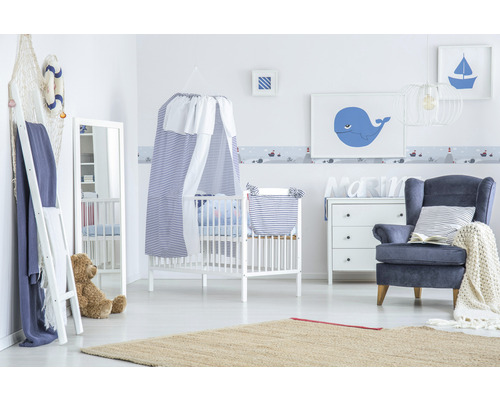 Chambre de bébé de style marin avec lit à barreaux, fauteuil et décoration assortie