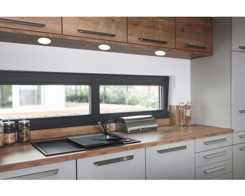 Cuisine moderne avec des tons de bois et de gris, plan de travail, évier et fenêtre