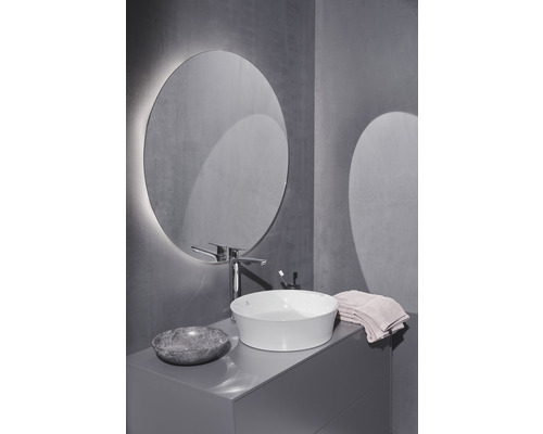 Badezimmer mit rundem Spiegel, Aufsatzwaschbecken, Armatur und Waschtischunterschrank