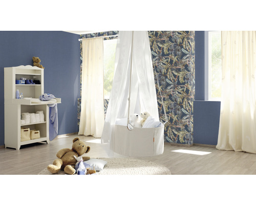 Chambre d''enfant lumineuse avec table à langer, berceau avec ciel de lit et ours en peluche