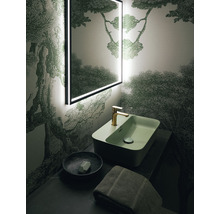 Badezimmer mit beleuchtetem Spiegel, Waschbecken, Armatur, Seifenschale und Handtuch