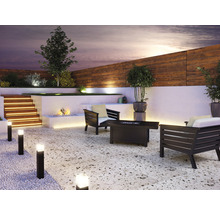 Terrasse mit Gartenmöbeln, Beleuchtung und Feuerstelle für eine gemütliche Atmosphäre