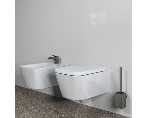 Vue de salle de bains avec WC suspendu, bidet, plaque de commande et brosse de toilette pour une ambiance moderne