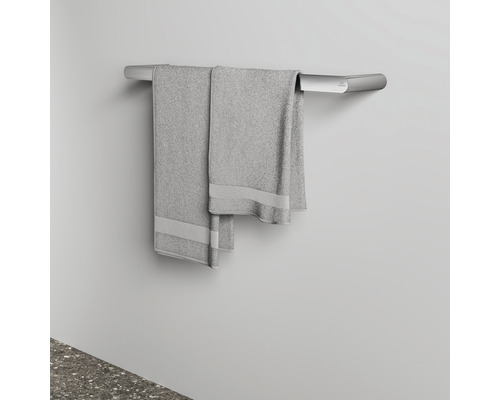 Silberfarbener Handtuchhalter mit grauen Handtüchern an einer Wand