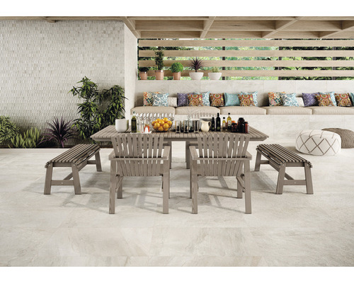 Aussenbereich mit Gartentisch, Stühlen, Bänken und dekorativen Kissen