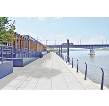 Dalles de trottoir sur une promenade au bord de l''eau avec un pont en arrière-plan