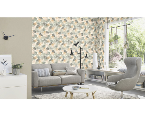 Wohnzimmer mit Sofa, Sessel und Tapete mit Blättermuster