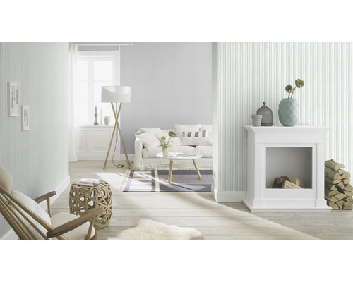 Espace de vie lumineux avec papier peint rayé, canapé, cheminée et parquet pour une ambiance chaleureuse
