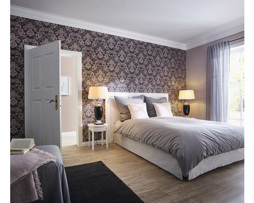 Chambre avec lit, tables de chevet, lampes et papier peint à motifs