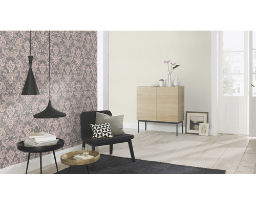 Salon avec papier peint à motifs floraux, fauteuil, tables d''appoint et armoire en bois