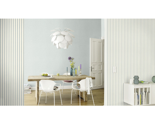 Salle de séjour avec table à manger, chaises, lampe et papier peint rayé