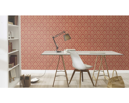 Arbeitszimmer mit roter und gemusterter Tapete, Schreibtisch und Bücherregal