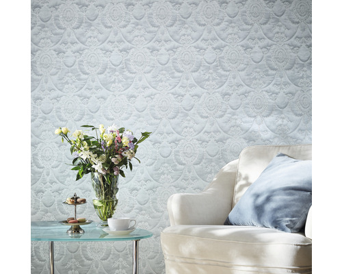 Salon décoratif avec papier peint à motifs, fauteuil et bouquet de fleurs