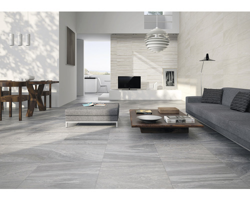 Salon lumineux avec carrelage gris, canapé et table en bois