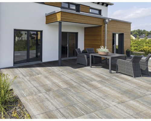 Terrasse mit Gartenmöbeln und Pflastersteinen vor einem Haus