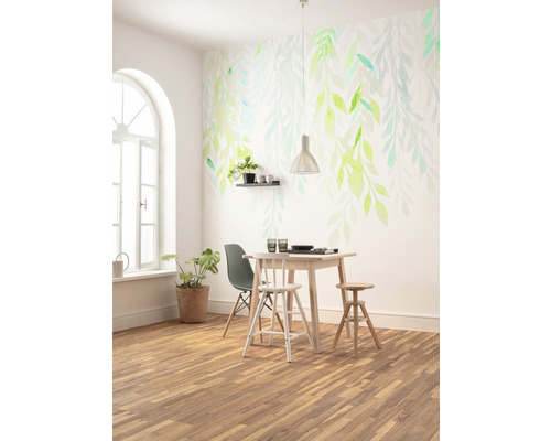 Salle à manger lumineuse avec parquet, table à manger, chaises et revêtement mural avec motif de feuilles