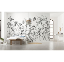 Geräumiges Schlafzimmer mit floraler Fototapete, Bett und Flechtlampe