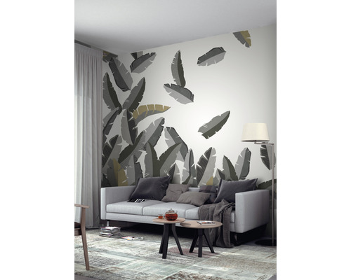 Wohnzimmer mit Tapete mit Blättermotiv, Sofa, Tisch und Stehlampe