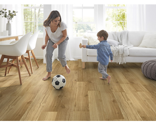 Helles Wohnzimmer mit Holzfußboden, Frau und Kind spielen mit einem Fußball