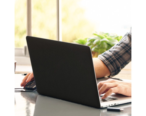 Person arbeitet mit einem Laptop am Schreibtisch