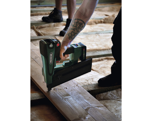 Eine Person befestigt eine Holzplanke mit einem Prebena Nagelgerät.