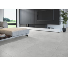 Salon lumineux avec carrelage, canapé et meuble média