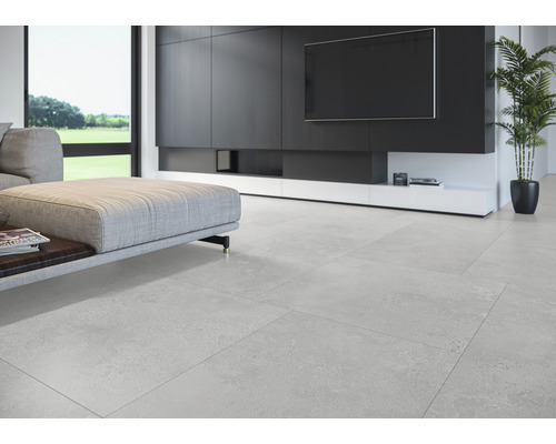 Salon lumineux avec carrelage, canapé et meuble média