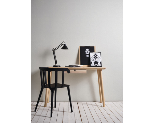 Schreibtisch mit schwarzem Stuhl, Schreibtischlampe und Bilderrahmen