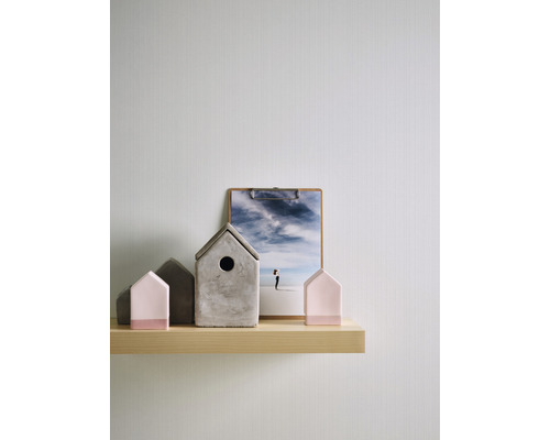 Dekorative Häuser und ein Bild auf einem Holzregal.