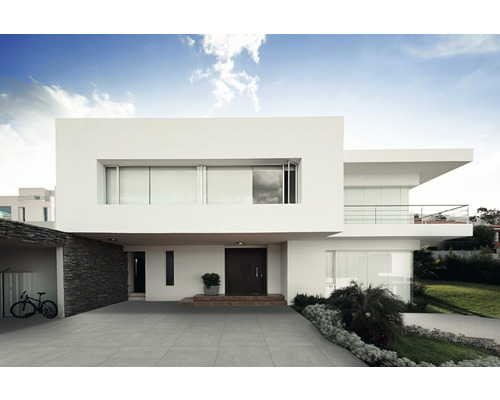 Maison moderne avec allée carrelée grise et design minimaliste.