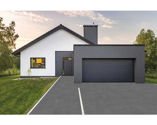 Modernes Einfamilienhaus mit Garage und gepflasterter Auffahrt.