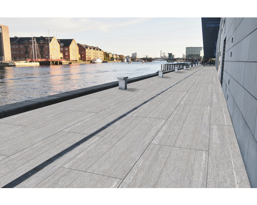 Blick auf eine Uferpromenade mit Bodenplatten und Entwässerungsrinne